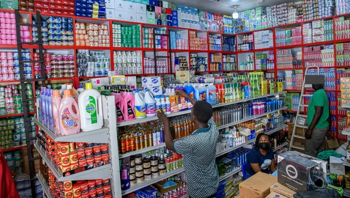 A shopkeeper inside a stocked retail shop